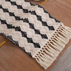 a black and white rug sitting on top of a wooden floor next to a plate