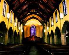 an empty church with stained glass windows and pews