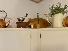 there are many pots and pans on top of the cabinets