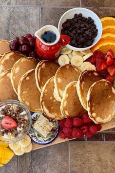 pancakes, fruit and chocolate chips are arranged on a platter for a breakfast buffet