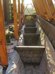 several buckets are lined up on the side of a wall in an outdoor area