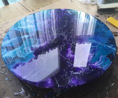 a table that has some kind of blue and purple design on it, sitting in the middle of a room