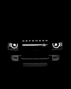 the front end of a black suv in the dark