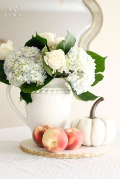 a white vase filled with flowers and peaches