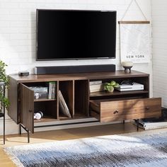 a flat screen tv sitting on top of a wooden entertainment center in a living room