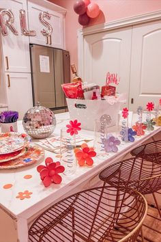 a white table topped with plates and bowls filled with confetti, candy and decorations