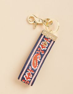 a keychain with a red, white and blue design on the front is attached to a gold - toned metal hook