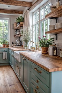 a kitchen filled with lots of green cabinets and wooden counter tops next to a window