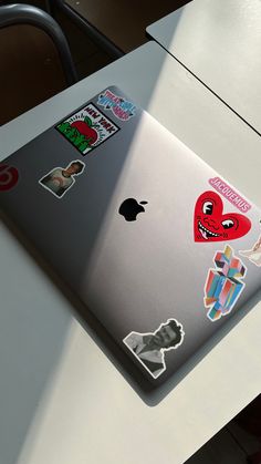 an apple laptop with stickers on it