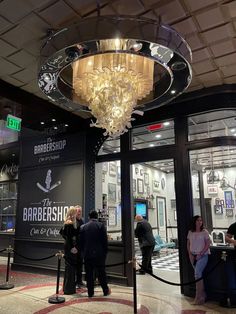 people standing in front of a store with chandelier hanging from the ceiling