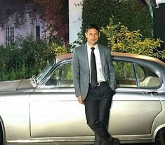 a man standing next to a silver car