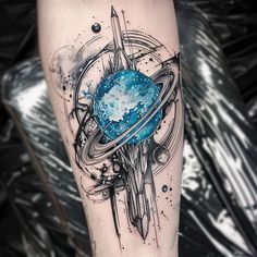 an artistic tattoo on the leg of a person with a blue planet in the center