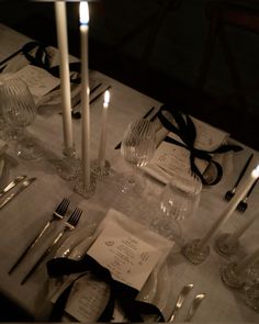 the table is set with silverware, candles and napkins for an elegant dinner