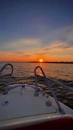 the sun is setting over the water as seen from a boat