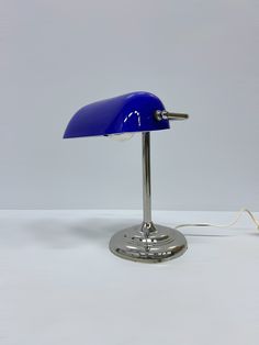 a blue table lamp sitting on top of a white floor