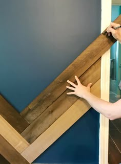 a woman is painting the wall with blue paint