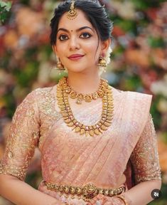 a woman in a pink sari and gold jewelry