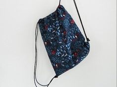 a drawstring bag hanging on the wall with an animal print pattern and black string