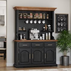 a coffee bar with black cabinets and gold trim around the top, along with a potted plant