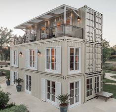 a house made out of shipping containers with windows and balconies on the second floor