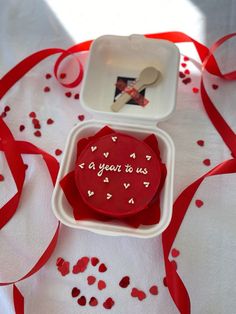 a red heart shaped cookie sitting in a white container