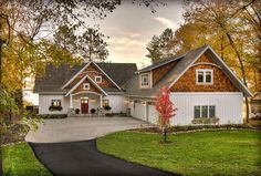 an image of a house in the middle of fall with leaves on the ground and trees around it