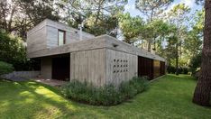 the house is made out of wood and sits in the middle of some green grass