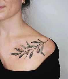 a woman's chest with olives and leaves on it