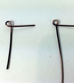 two pairs of metal hooks on a white surface