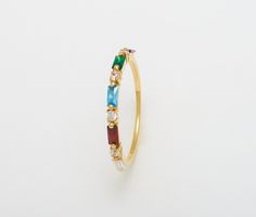 a gold ring with different colored stones on it