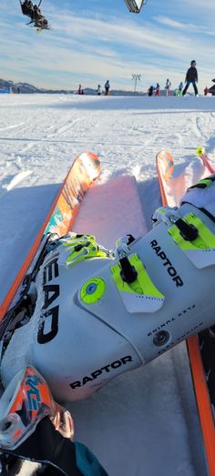 a pair of skis sitting in the snow next to an orange and white pole