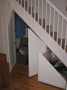 an open closet under the stairs in a house