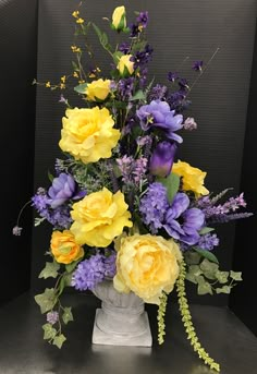 a vase filled with yellow and purple flowers