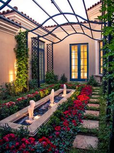 an outdoor garden with flowers and plants in the center, surrounded by a pergolated roof