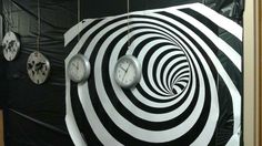 there are clocks hanging on the wall with black and white stripes around them in this room