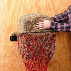 a person is holding onto a hay bale