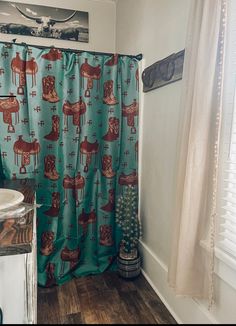 a bathroom with a blue shower curtain and wooden flooring, along with a small christmas tree