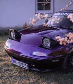 a purple sports car parked in front of a house