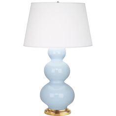 a light blue lamp with a white shade on it's side and a gold base