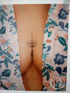 a small tattoo on the side of a woman's breast, with an insect crawling through it