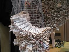 a bunch of papers that are hanging from a wire mesh net on a table top