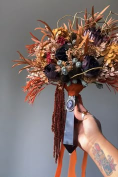 a person holding up a bouquet with flowers on it's head and an old camera in their hand