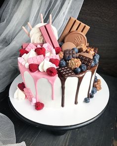 a cake decorated with chocolate, raspberries and blueberries