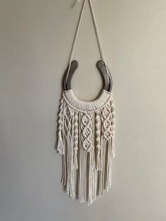 a white purse hanging from a hook on a wall