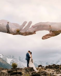 two hands reaching out to touch each other in front of a mountain range with snow capped mountains