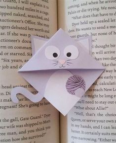 an origami cat is sitting on top of the book