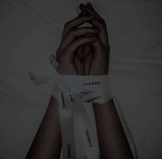 a person's hands wrapped in ribbons with the words chanel on them,