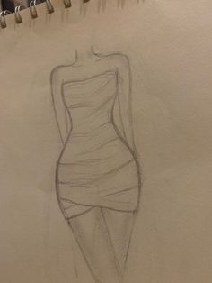 a drawing of a woman's dress on a piece of paper with pencils