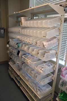 the shelves are filled with plastic containers and other items for storage in an office building