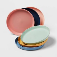 four plates stacked on top of each other with different colored rims in the middle